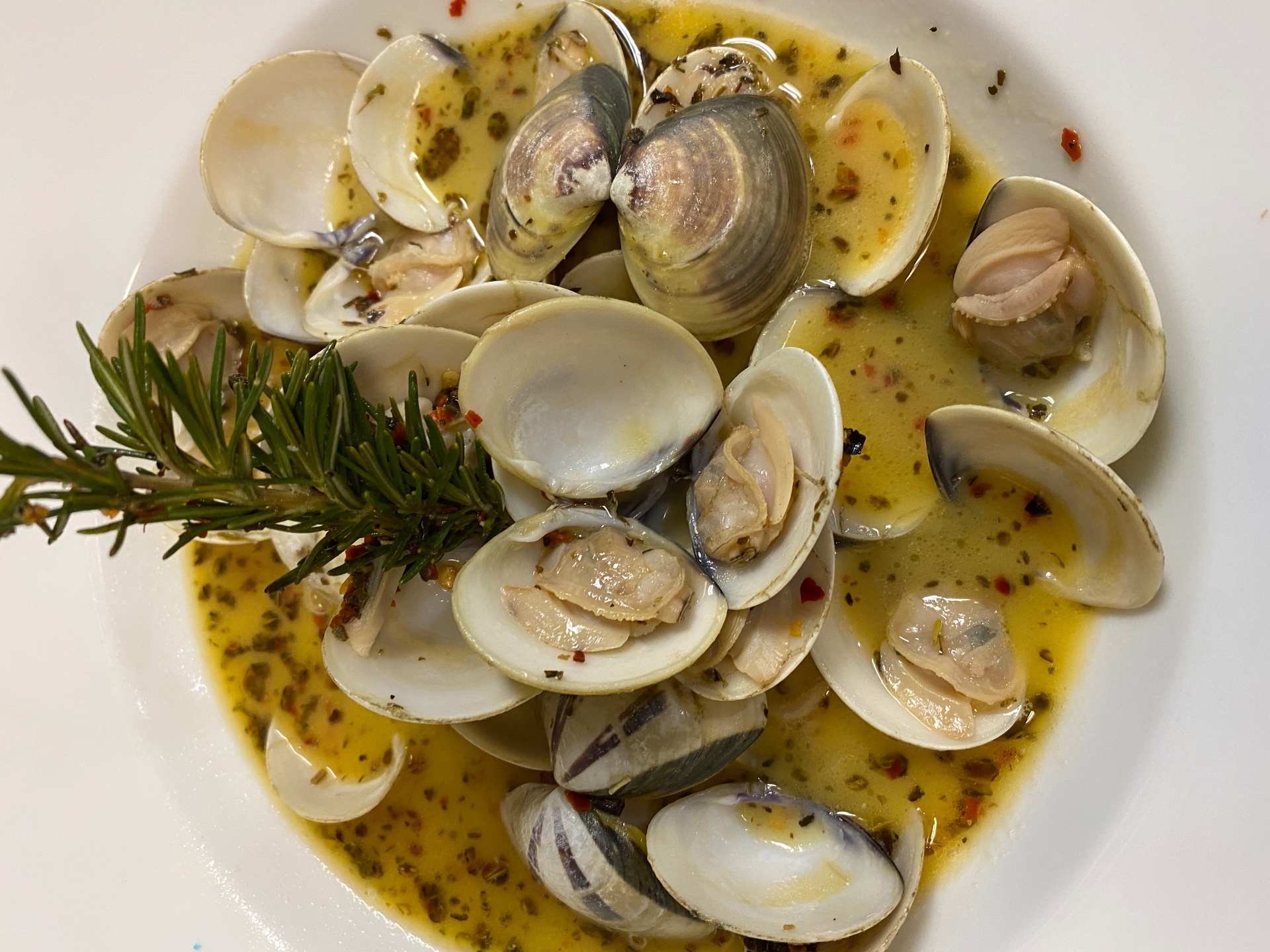 Steamed clams in garlic herb butter with fresh rosemary