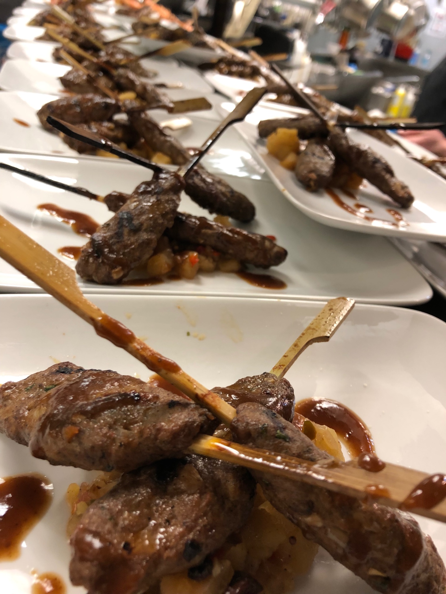 Plated beef skewers with glaze over grilled pineapple relish
